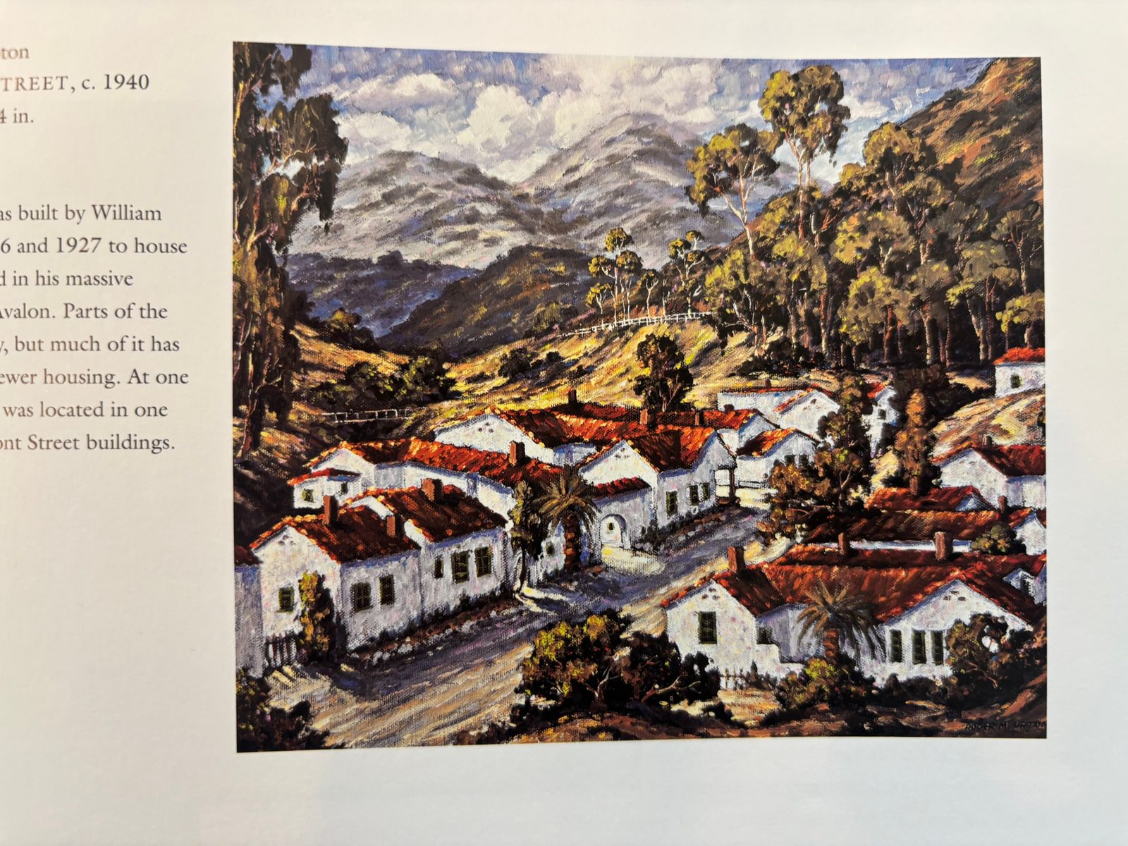 Painting of white stucco houses with red tile roofs beneath eucalyptus-covered hills in Avalon